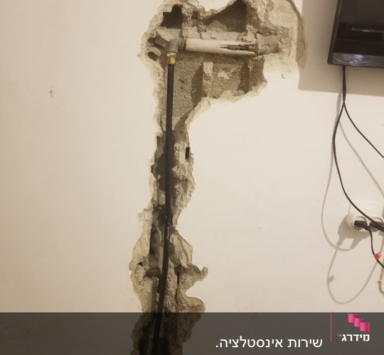 צינור מים חשוף בקיר עם חיבורי אינסטלציה